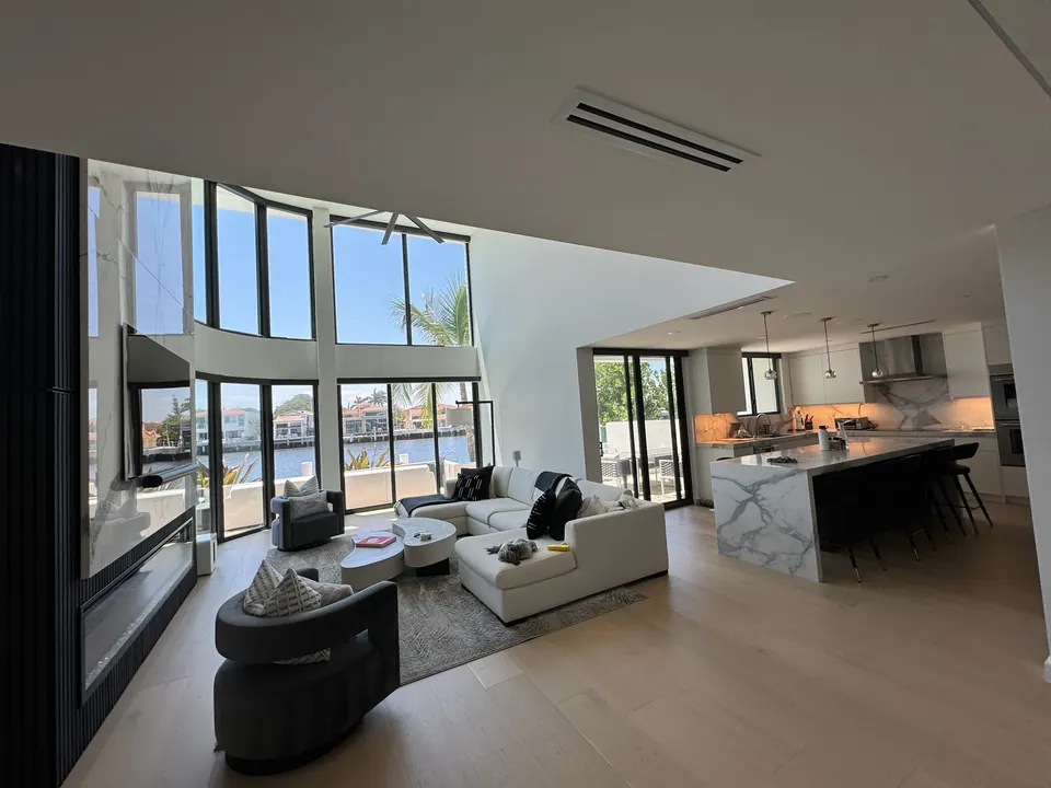 Wide plank flooring running through an open great room and kitchen with waterway views